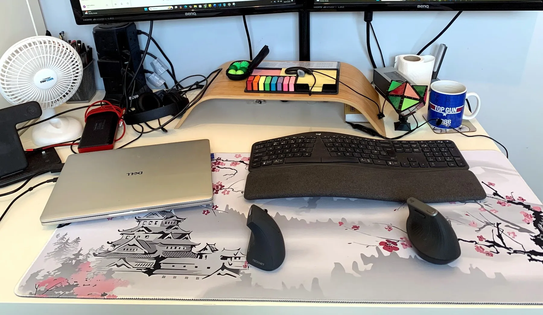 Home office desk with Logitech ergonomic keyboard, two vertical mice, laptop and large Japanese-style desk mat