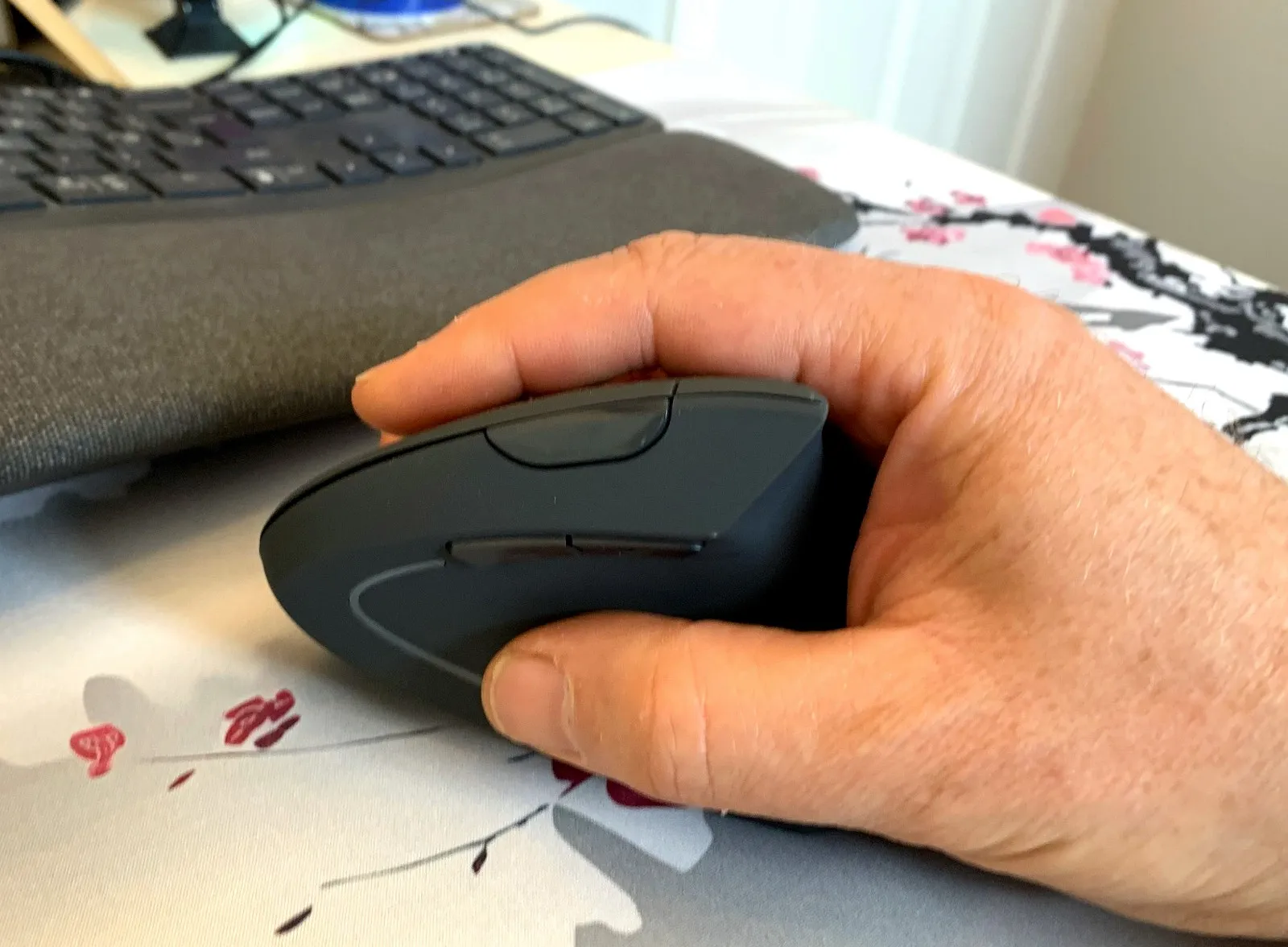 Hand using the smaller TECKNET vertical mouse